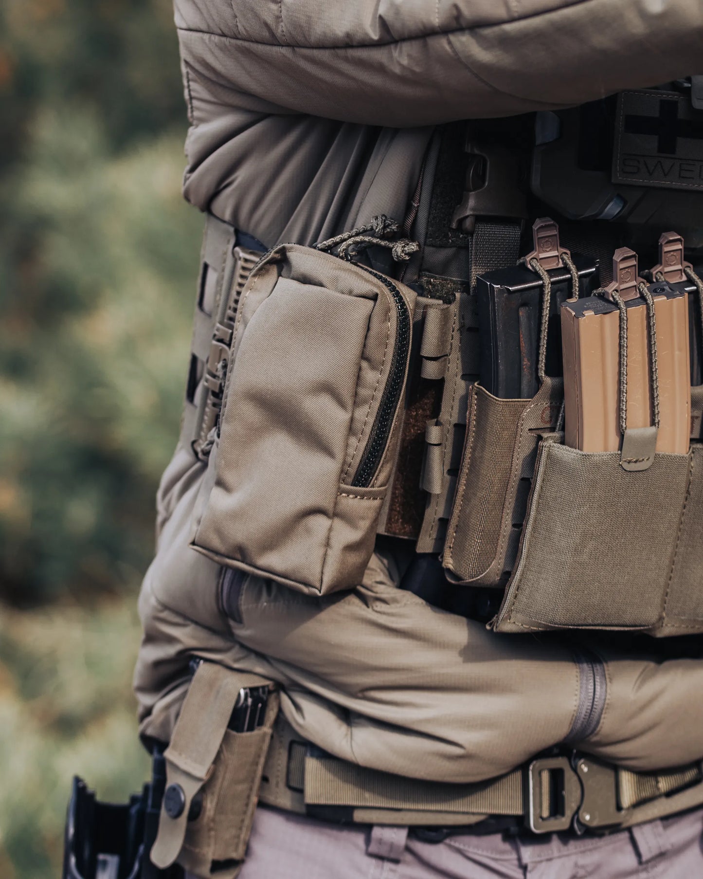 Liten flerbruksficka i Ranger Green monterad på plate carrier